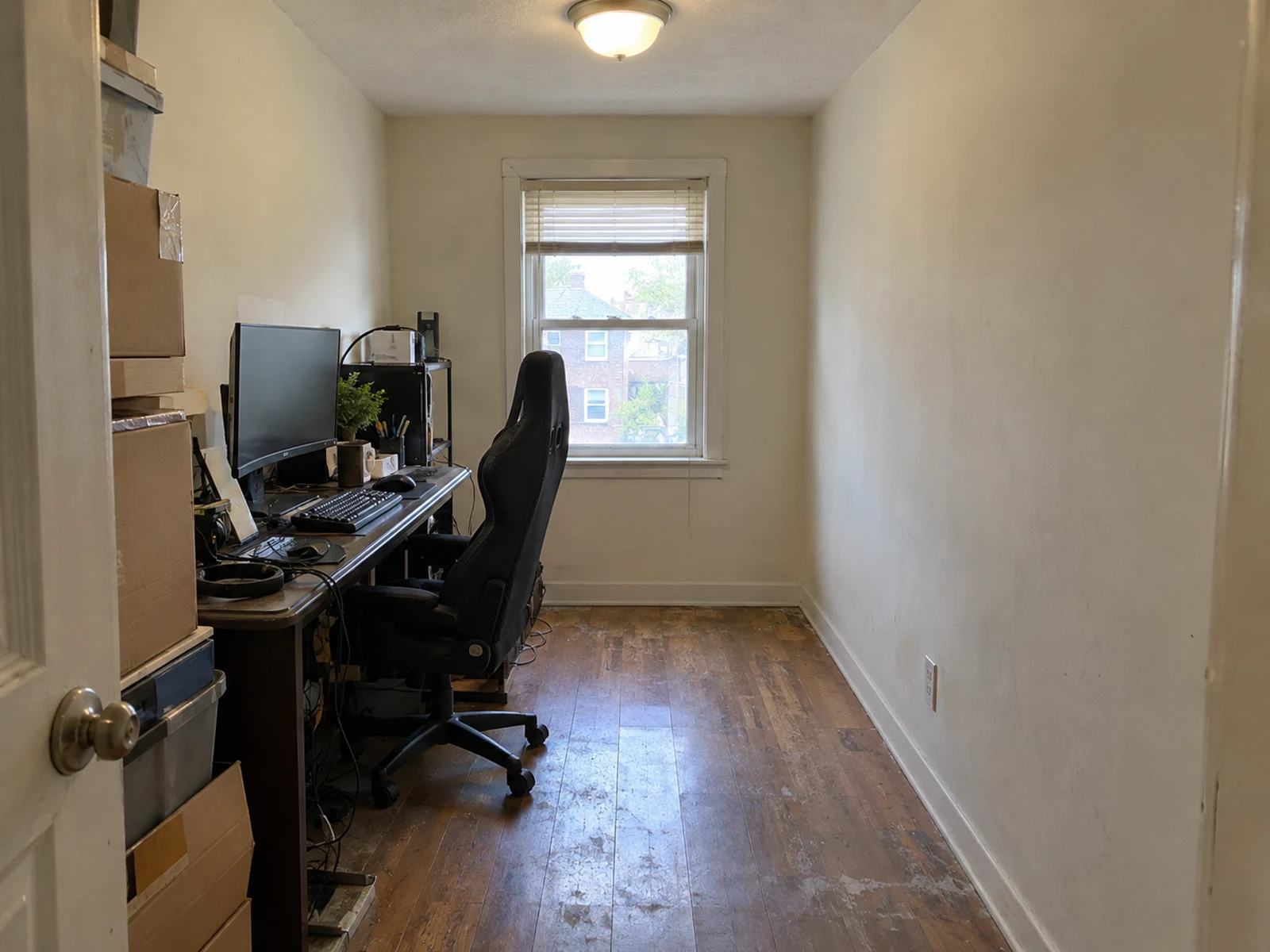 Narrow work room with a cluttered desk before AI home office redesign