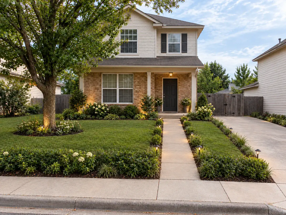 Front yard after AI yard design with a clearer entry, layered planting, tidy driveway edge, and warm path lighting
